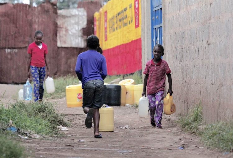 Kinder mit Wasserkanistern im Slum Korogocho in Nairobi während der Corona-Pandemie. | Foto © Ayiera Initiative